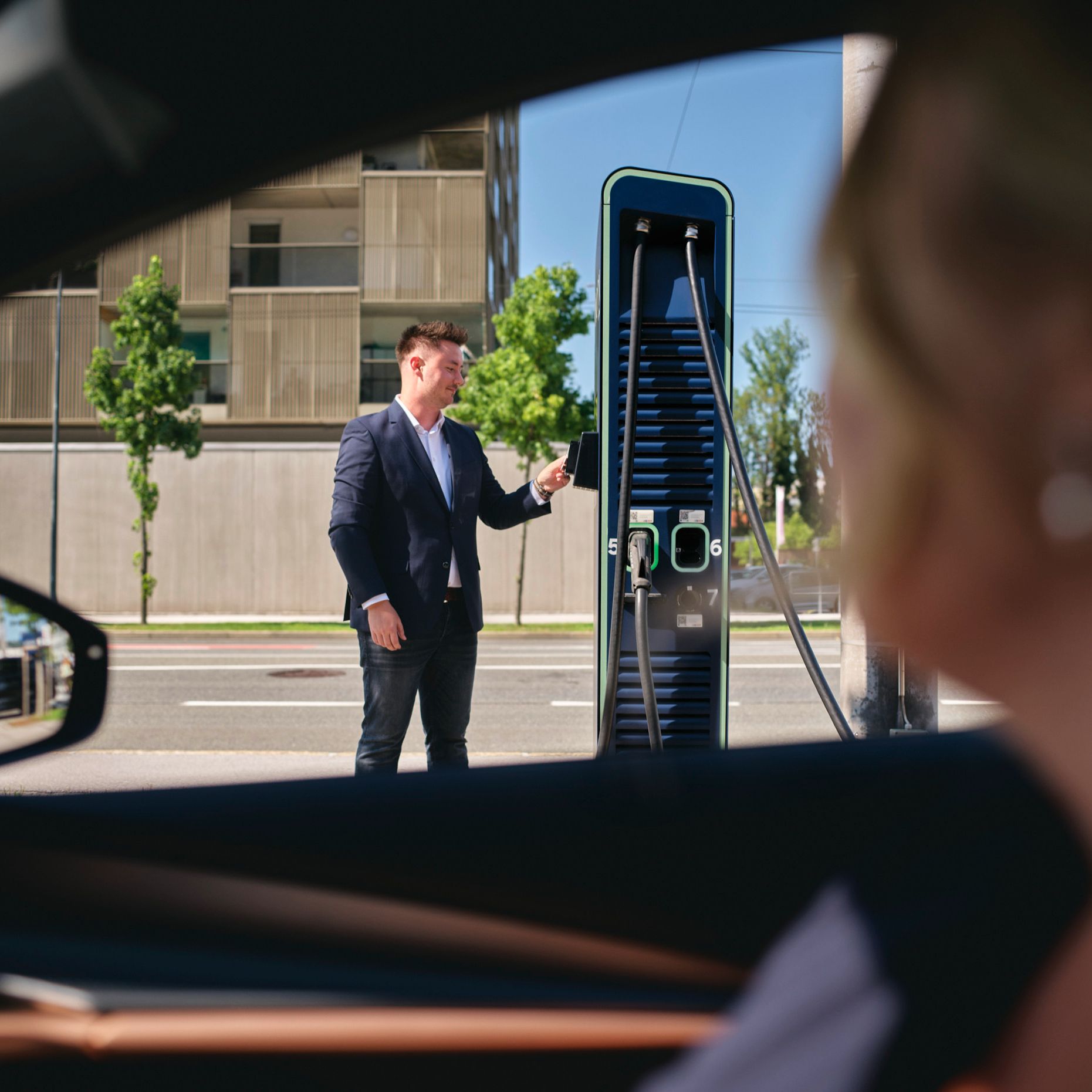 Man standing in front of a fast charging station with a card